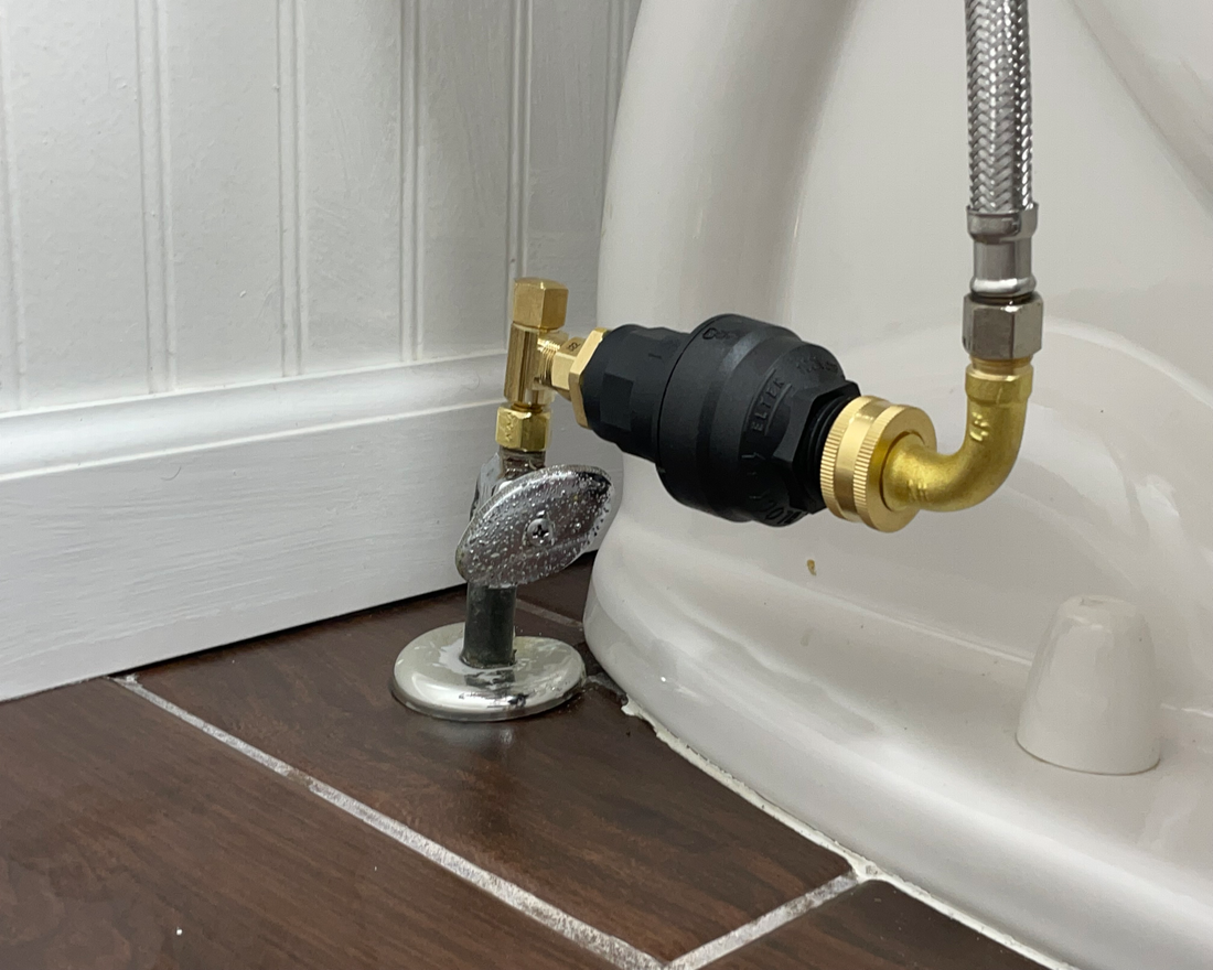 Water Block water shutoff device installed in the vertical position on a toilet shutoff valve. The device is connected to a stainless steel braided toilet hose.