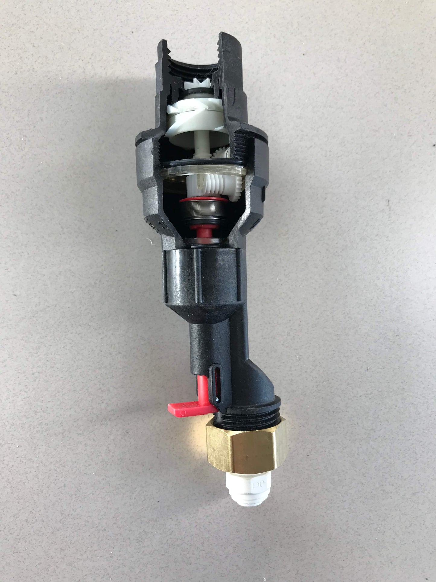 A mechanical inside look of the Water Block. The gears and springs can be seen to better understand how the device works. 1/4" quick connect fitting on the outlet side of the reset device.
