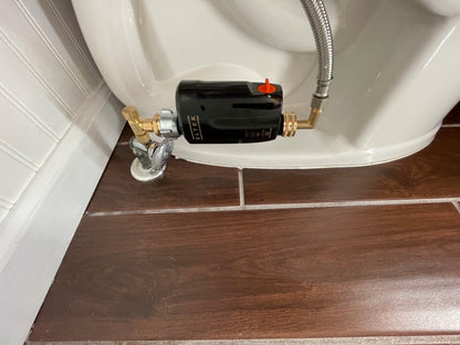 E-WaterBlock Bluetooth device installed on a toilet, monitoring water flow and detecting abnormal conditions that may indicate a leak or running water.