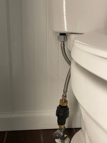 A Water Block Leak Stop Device is installed on a toilet to prevent leaks. The device is connected to the supply valve and to the toilet tank with 3/8" brass fittings. The device has a preset volume setting that will activate the shutoff valve if a leak exceeds that volume. This helps to prevent flooding and water damage.